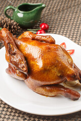 Hong Kong-style crispy chicken, served on a white round porcelain plate, is placed on a placemat.