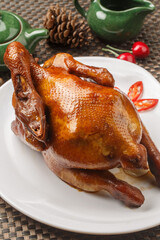 Hong Kong-style crispy chicken, served on a white round porcelain plate, is placed on a placemat.