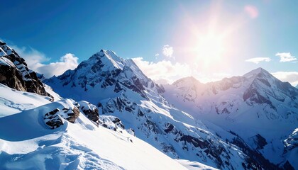 A breathtaking view of snow-capped mountain peaks bathed in bright sunlight against a clear blue sky with scattered clouds.