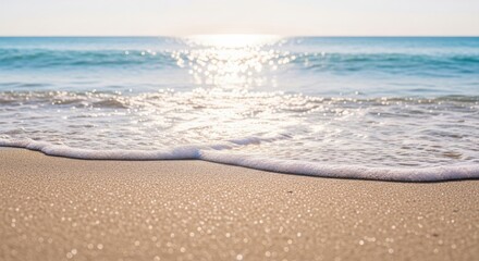 Calm ocean waves gently lapping onto the sandy shore on a sunny day
