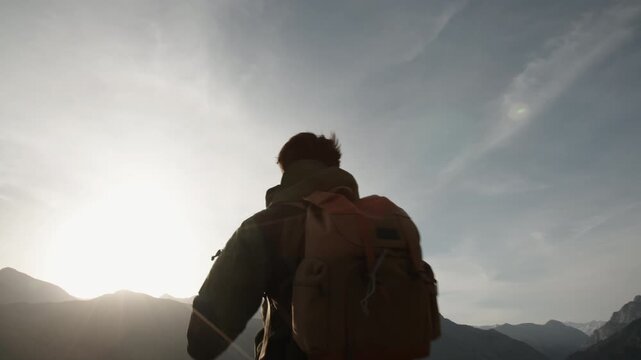 Traveler facing sunrise spreading arms wide camera moving from sun to silhouette concept of freedom awakening inner peace gratitude connection with world and personal transformation