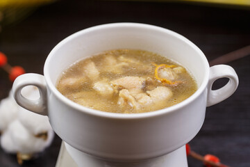 Cordyceps flower and pig's trotter soup served in a white porcelain soup bowl