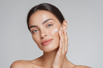 Woman applying facial cream with gentle smile, showcasing healthy skin and natural glow. image captures moment of self care and beauty routine, emphasizing skincare