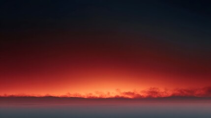 Obraz premium Dramatic sunset horizon glowing with vibrant red and orange hues with atmospheric clouds below