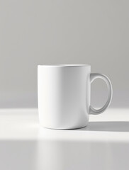 Obraz premium Clean and simple white ceramic coffee mug mockup sitting on a minimalist surface with natural side lighting