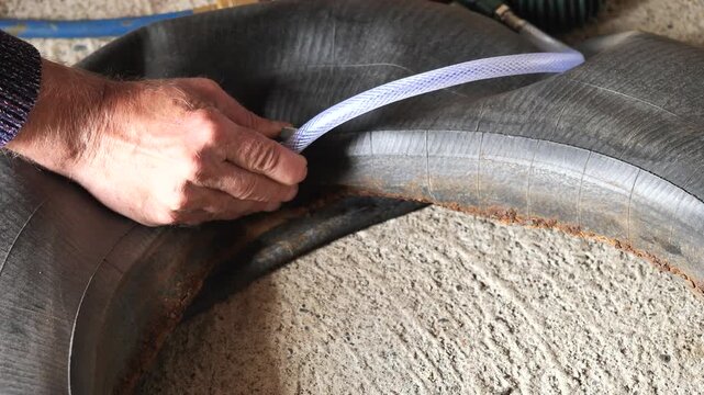 a man inflates an old rubber inner tube