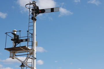 Two old-fashioned railway semaphore signals and blue sky background
