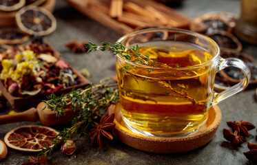 Cup of herbal tea with ingredients on the kitchen table.