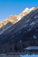 Snow-Capped Alpine Peaks with Mountain Lodge in Winter Valley