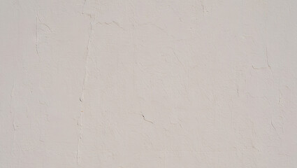 A textured wall surface showcases a neutral light color. The subtle variations in texture add depth, creating a calm and minimalistic feel in the space during midday hours