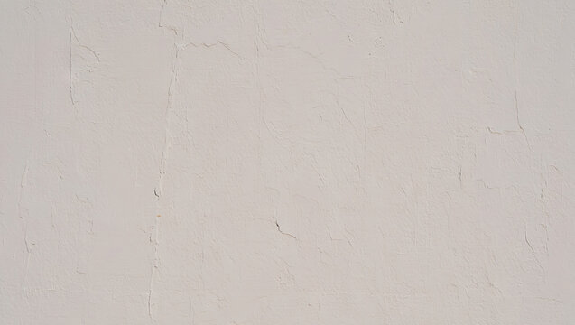 A textured wall surface showcases a neutral light color. The subtle variations in texture add depth, creating a calm and minimalistic feel in the space during midday hours