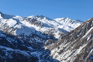 Majestic Snow-Capped Alpine Peaks and Winter Valley Under Clear Blue Sky