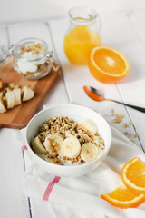 healthy breakfast bowl of yogurt with granola and banana