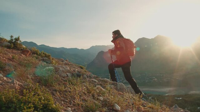 Traveler hiker climbing steep mountain with backpack and trekking poles concept of motivation challenge success outdoor freedom journey mindfulness adventure lifestyle inspiration
