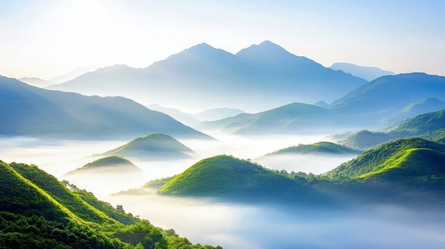 A serene landscape of layered mountains shrouded in mist, with lush green hills emerging from the fog.