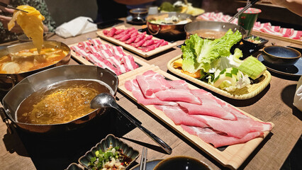 Premium sliced Snowflake beef and Premium pork sliced meat on a wooden board in a Japanese hotpot restaurant, vibrant textures and high-quality ingredients prepared for a comforting Asian shabu-shabu 