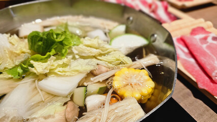 A premium Japanese shabu-shabu dining table set with assorted meats, fresh vegetables, hot pot broth,  full-set courses in an Asian restaurant, comforting flavors, warm steam, relaxing gourmet 