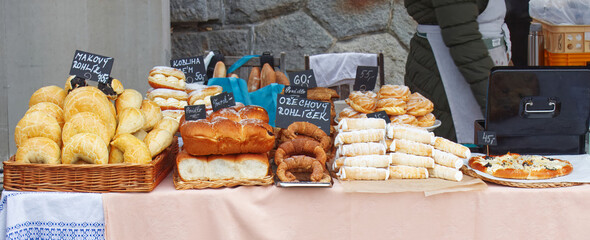 A vibrant bakery stall at Prague Naplavka Market showcasing a rich variety of fresh breads and pastries before crowds arrive on a crisp market morning.