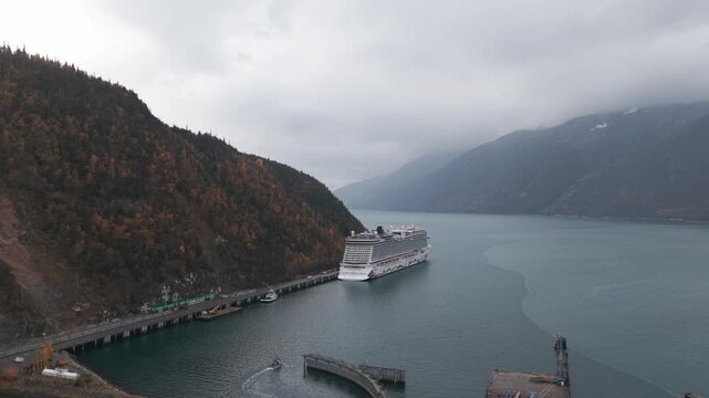 Wide panning aerial shot of the Skagway port with a cruise ship during the fall season in Southeast Alaska. 4K