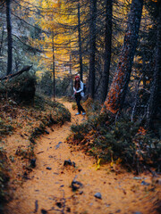 Obraz premium Woman hiking in the Swiss Alps in October with autumn-winter atmosphere, mountains and light snow