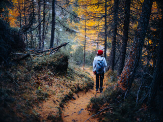 Obraz premium Woman hiking in the Swiss Alps in October with autumn-winter atmosphere, mountains and light snow