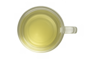 Green tea in glass mug, light yellow soothing hot beverage in transparent cup, top view of healthy drink