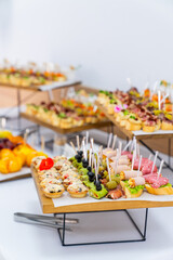 Assorted finger foods on display. Selection of diverse finger foods arranged neatly across elevated trays.