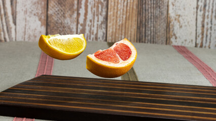 floating orange and grapefruit slices above wooden board