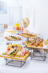 Banquet table with festive snacks. Elegant banquet setup featuring various snacks and bright celebratory decor.