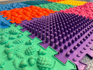 Colorful textured sensory floor tiles arranged in a close-up pattern highlighting diverse shapes and raised surfaces