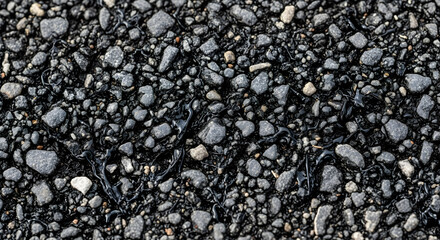 Close up shot of wet asphalt road surface with stones and bitumen