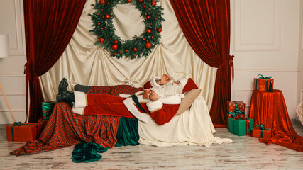 Santa Claus relaxing on a couch after a long day of Christmas preparations