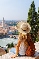 woman sitting on a wall enjoying beautiful view on Verona city in Italy. Verona is a famous city of love