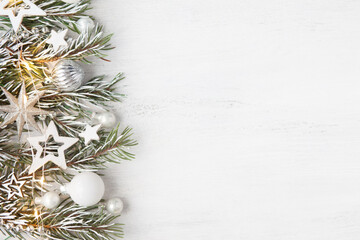 Branch of fir tree with Сhristmas ornaments on old white wooden shabby background with empty space for text. Christmas and New Year background with holiday decorations.