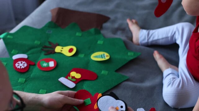 Father and his son decorating toy Christmas tree together. Educational games for children. 4K
