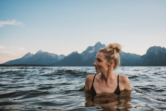 Beautiful woman swims in lake, Grand Teton National Park