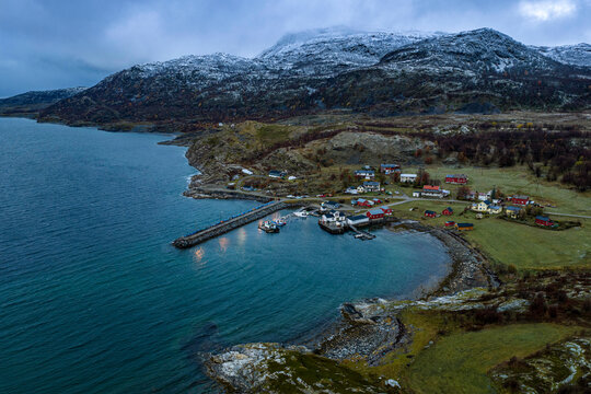 Quiet Arctic harbour beneath snow-covered mountains