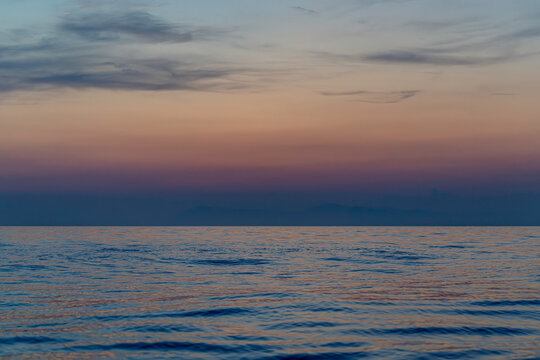Soft Pastel Sunset Over a Calm Open Sea - Powered by Adobe