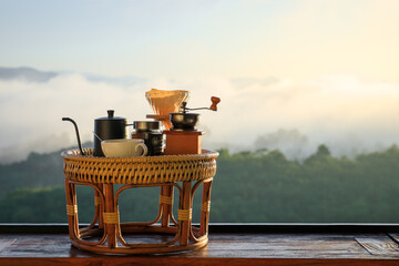 Drip coffee set on wooden table in morning with foggy background