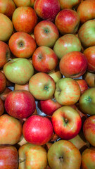 Red and green apples stacked in market display.