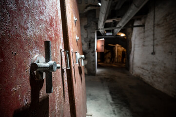 Red metal doors inside the historic underground bunker system in Nuremberg, Germany.
