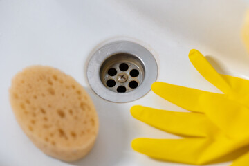 Yellow sponge and a dirty sink in rust close-up