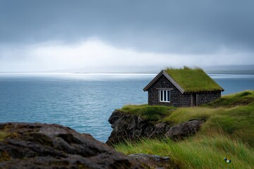 Secluded coastal cabin on cliff with grass roof overlooking ocean