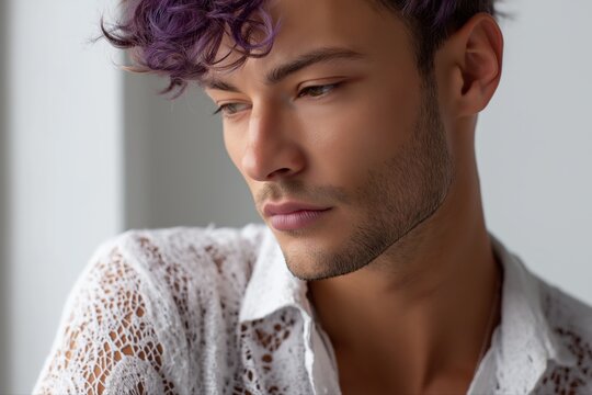 Young caucasian male with purple hair in thoughtful pose