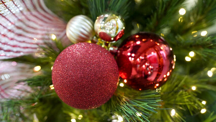 Close-up of red Christmas ornament with sparkling lights on decorated tree