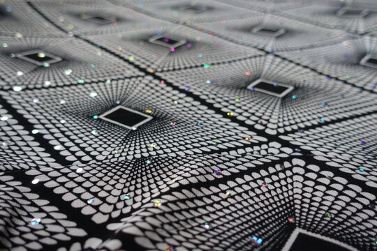 Close shot of black and white fabric with geometric pattern and sequins - Powered by Adobe