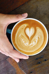 a cup of latte art coffee on wooden background                                       