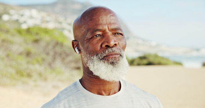 Thinking, senior black man and fitness on beach with vision, exercise and decision for break. Elderly person, earphones and reflection for training at sea, daydreaming and choice for retirement hobby - Powered by Adobe