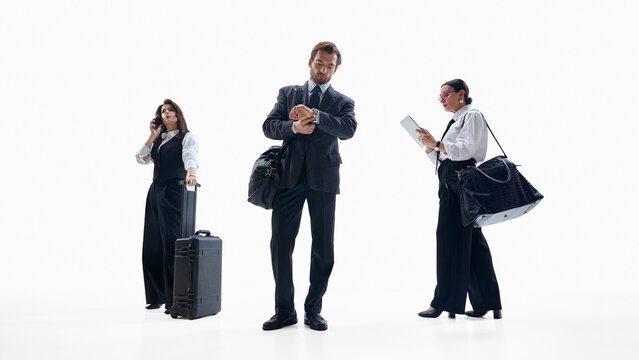 Diverse business team waiting with luggage and digital devices. Concept of corporate mobility workflows, travel communication, HR visuals, team coordination content.