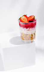 Delicious layered dessert with strawberries and cream on a white background
